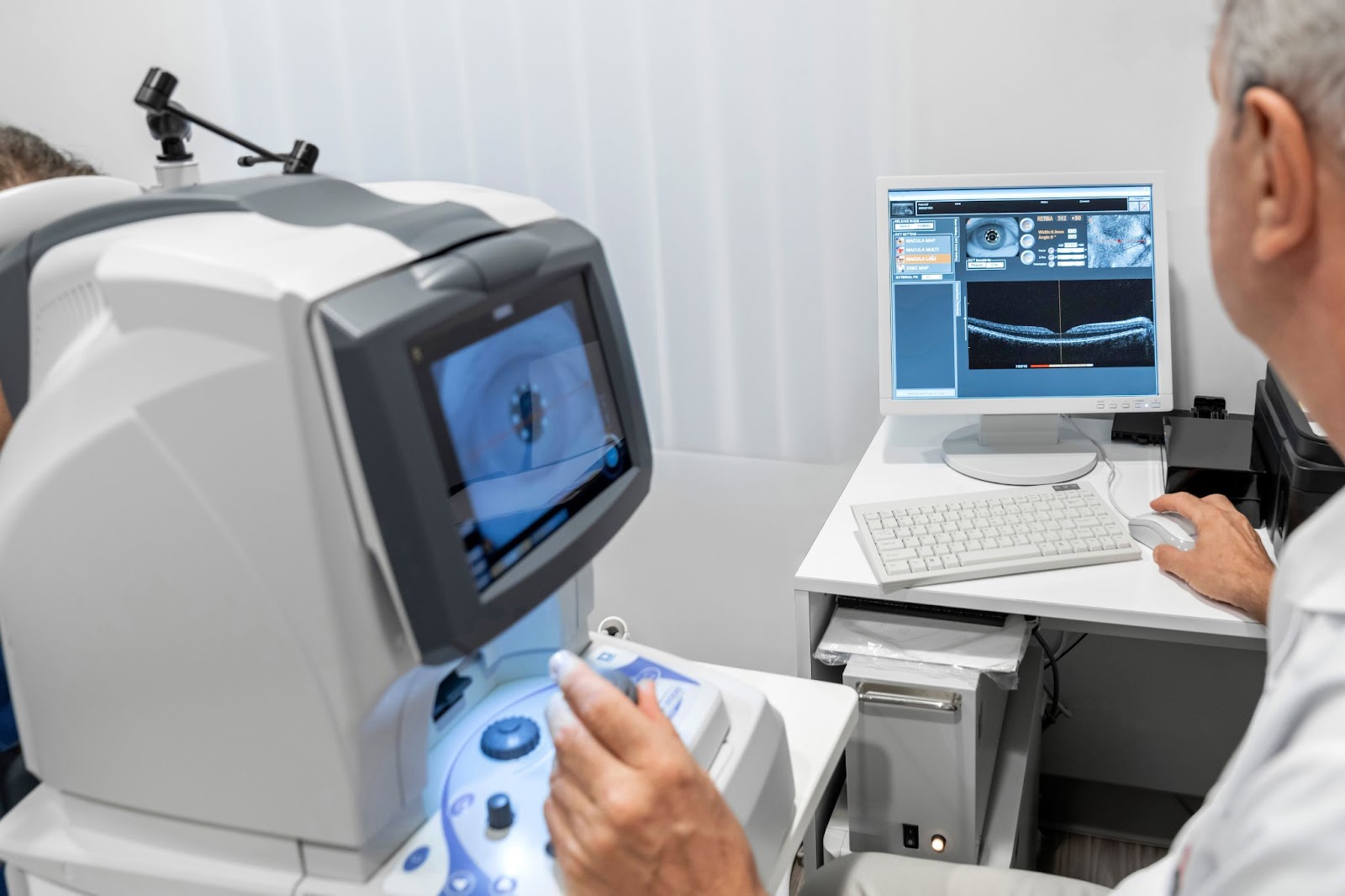 An optometrist examines a patient's vitreous scans during their routine eye exam appointment.